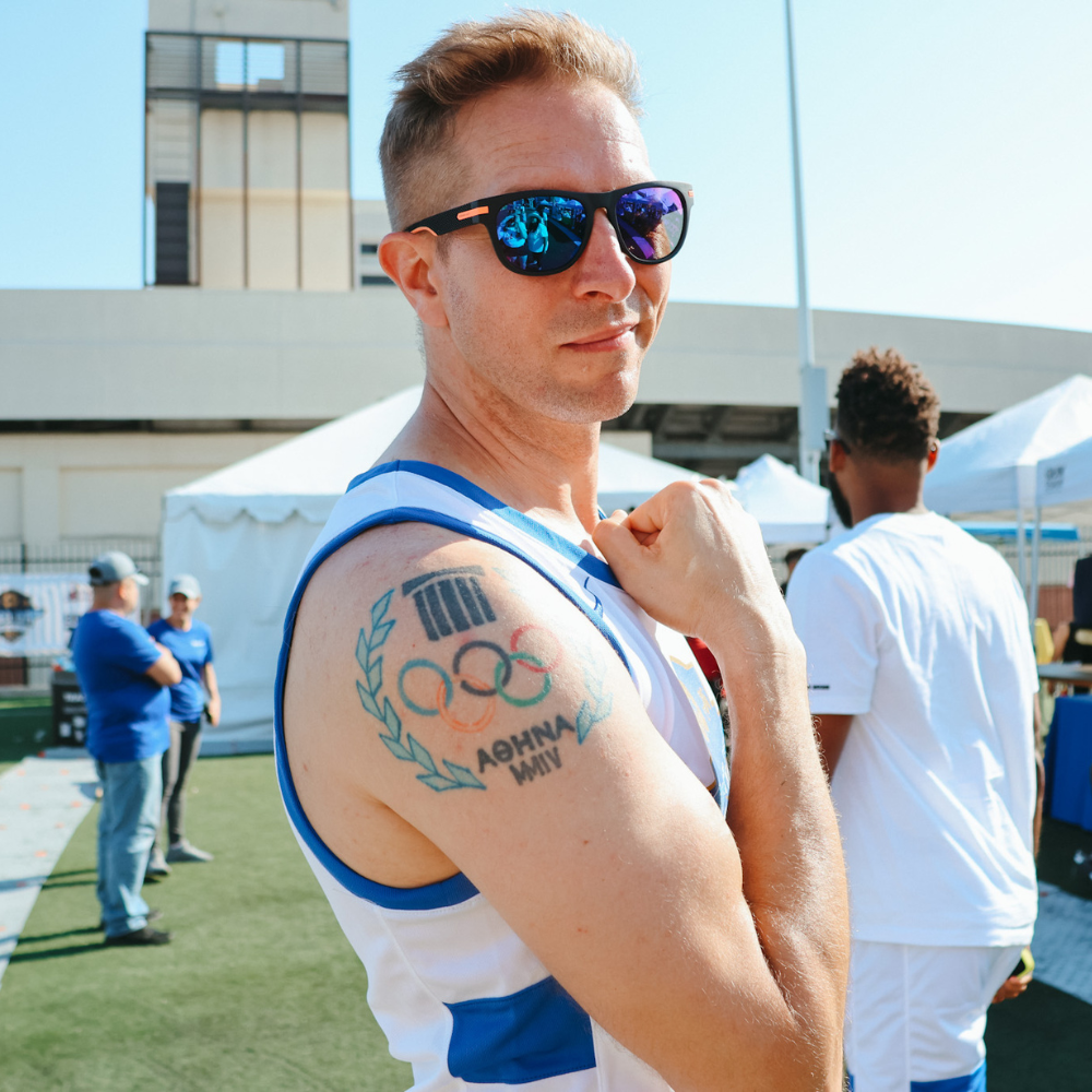 Cody Mattern flexing his right bicep that has a tattoo saying Athens 2004