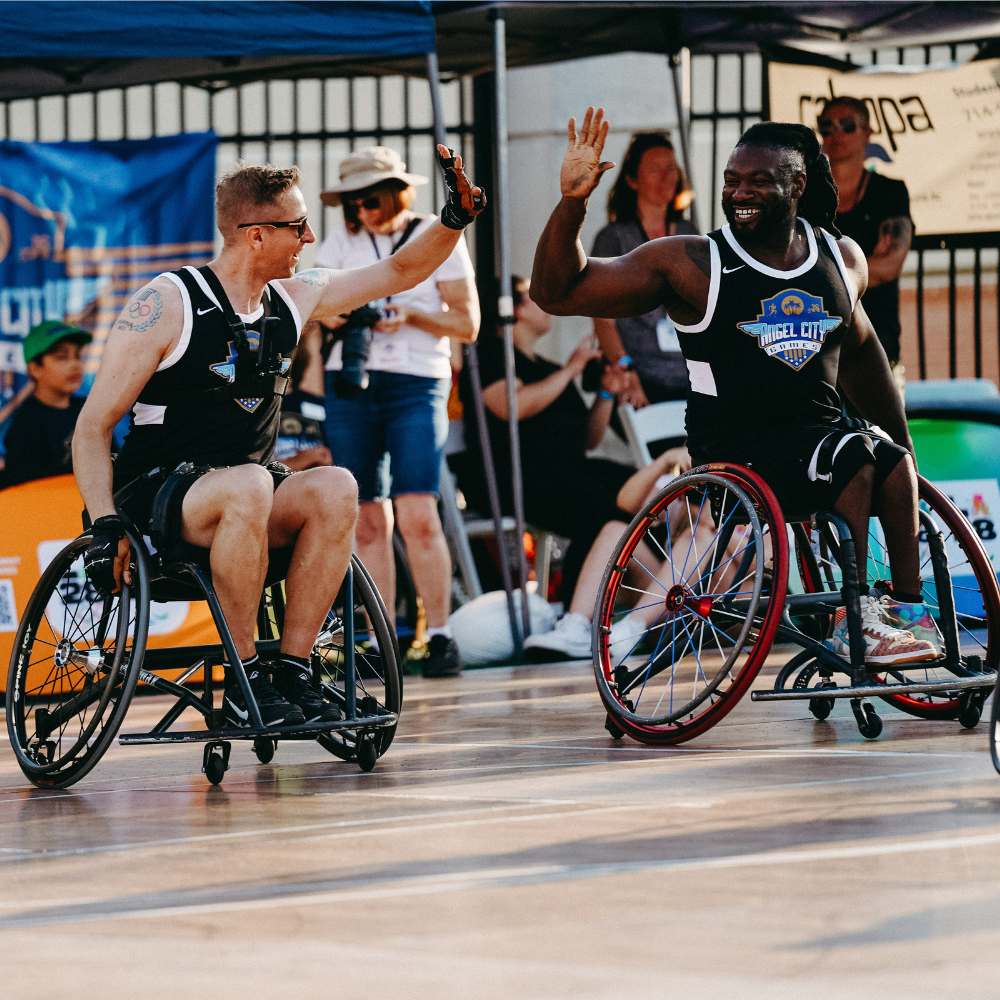 Cody Mattern giving a high five on a basketball court while playing wheelchair basketball
