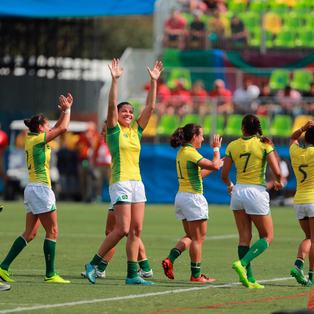 Izzy and her teammates on the rugby field clapping and cheering at Rio 2016