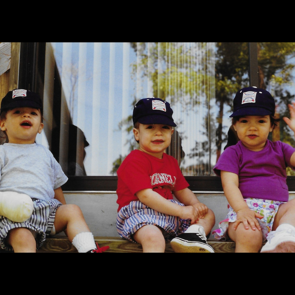 Izzy and her two brothers sitting together as babies