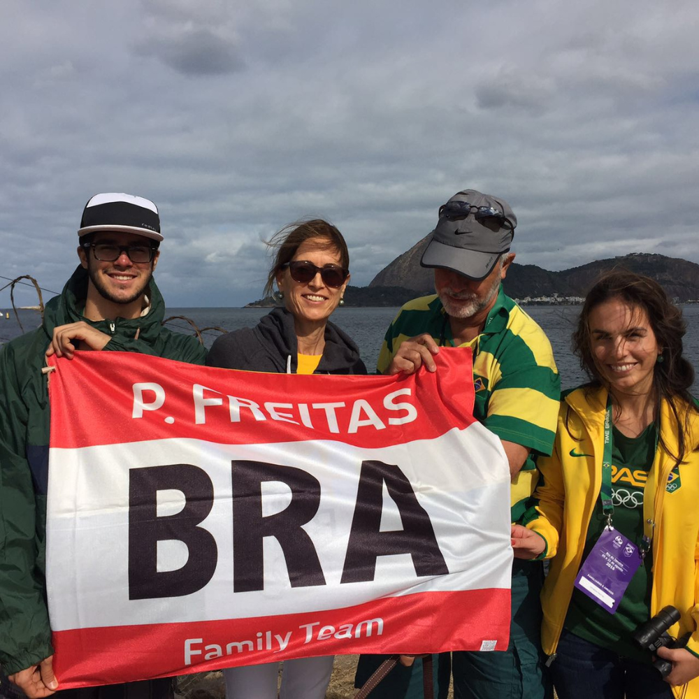 Patricia's family smiling and holding up a banner that says 'Freitas family team'