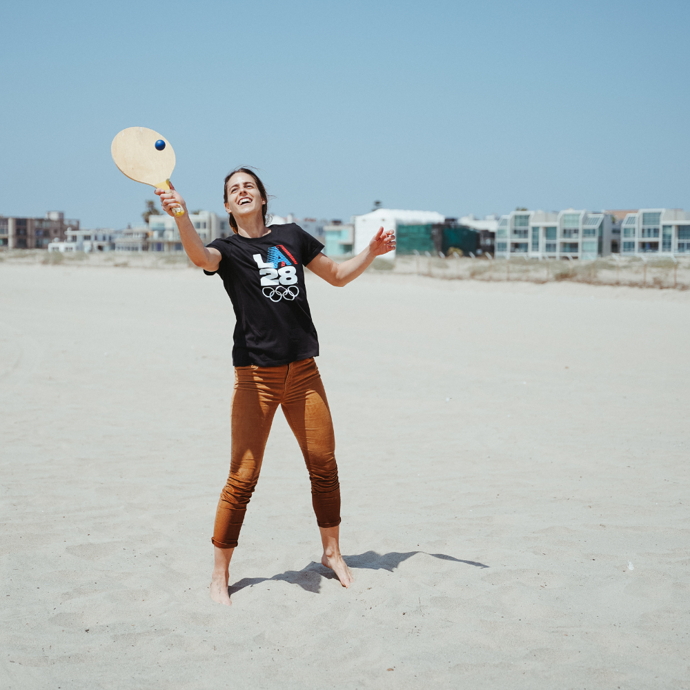 Image of Patricia smiling and playing smashball in the sand