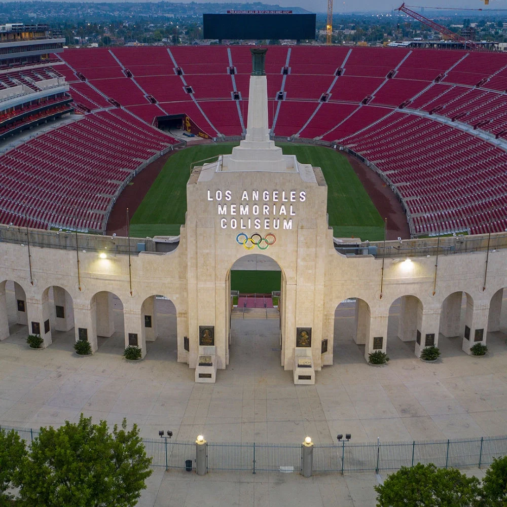 Foto de la entrada del Los Angeles Memorial Coliseum con las gradas y asientos visibles al fondo