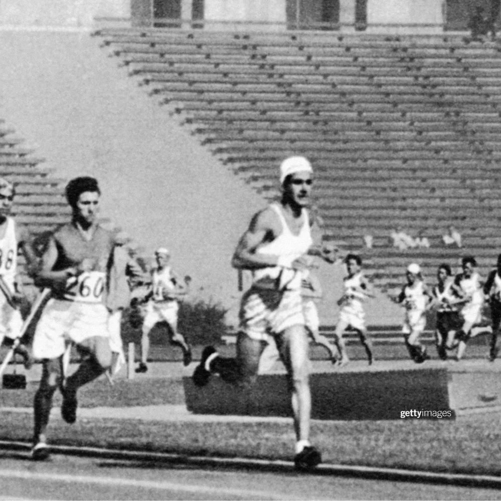 Foto en blanco y negro del atleta olímpico argentino Juan Carlos Zabala corriendo en una pista del Coliseo Memorial de Los Ángeles mientras gana la primera medalla de oro en Atletismo para su país en los Juegos de 1932.