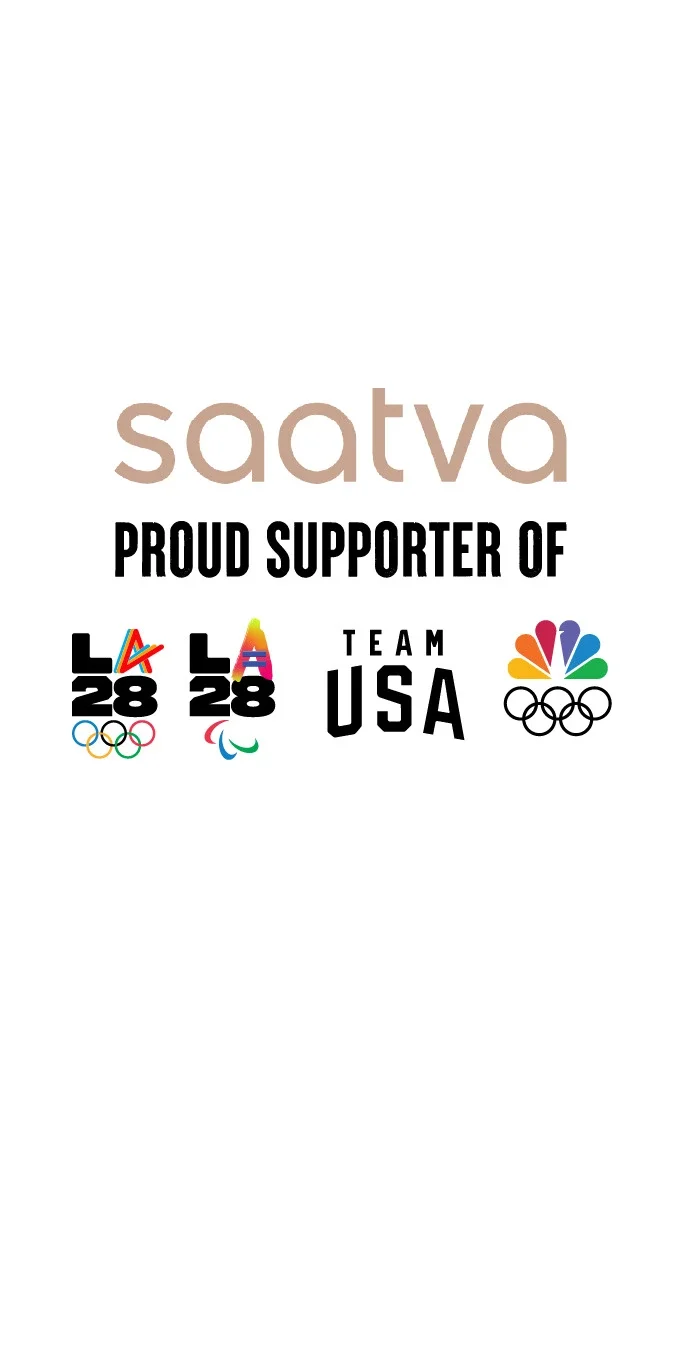 Imagen del logotipo de Saatva en letras doradas sobre las palabras "Orgulloso Patrocinador de", junto a los emblemas olímpicos y paralímpicos de LA28, el logotipo del Team USA y el logotipo del pavo real de NBC sobre los aros olímpicos.